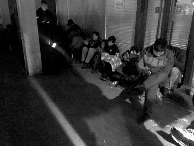 掛號人員蜷縮在門診大樓外通宵排隊(duì)。